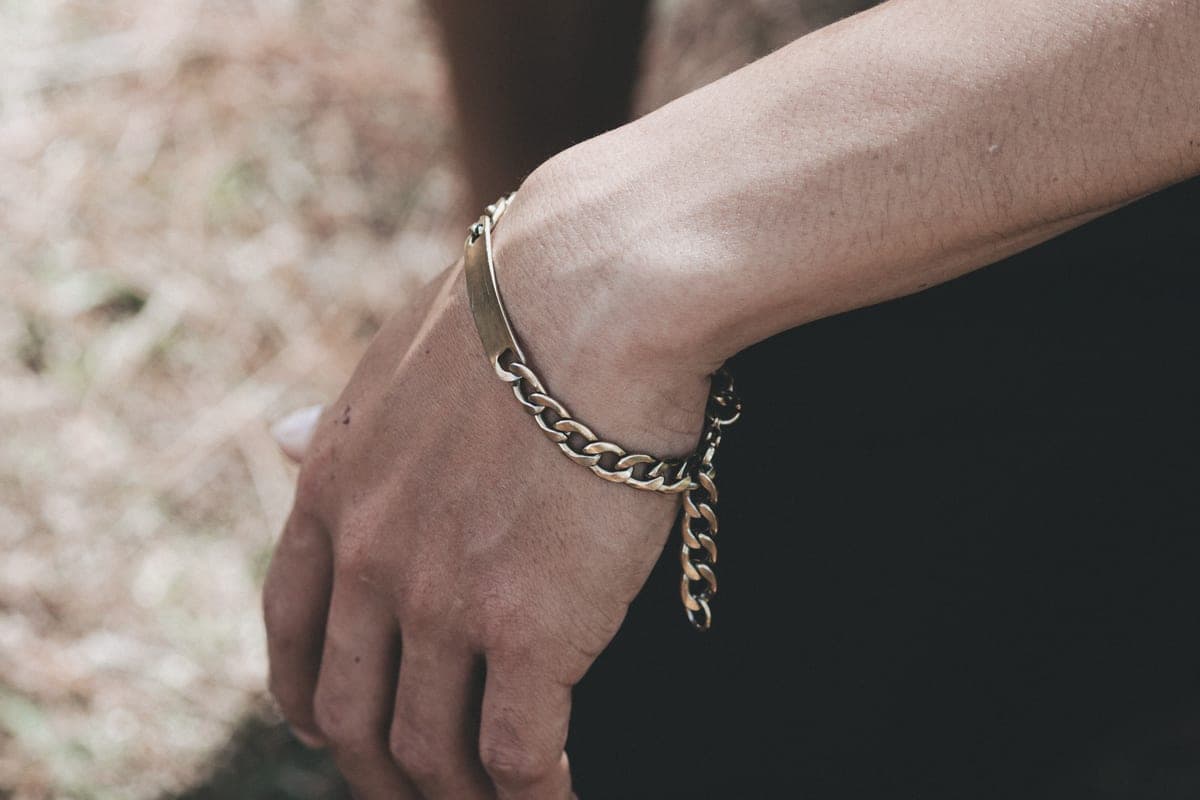 A fine chain bracelet on a wrist in soft daylight