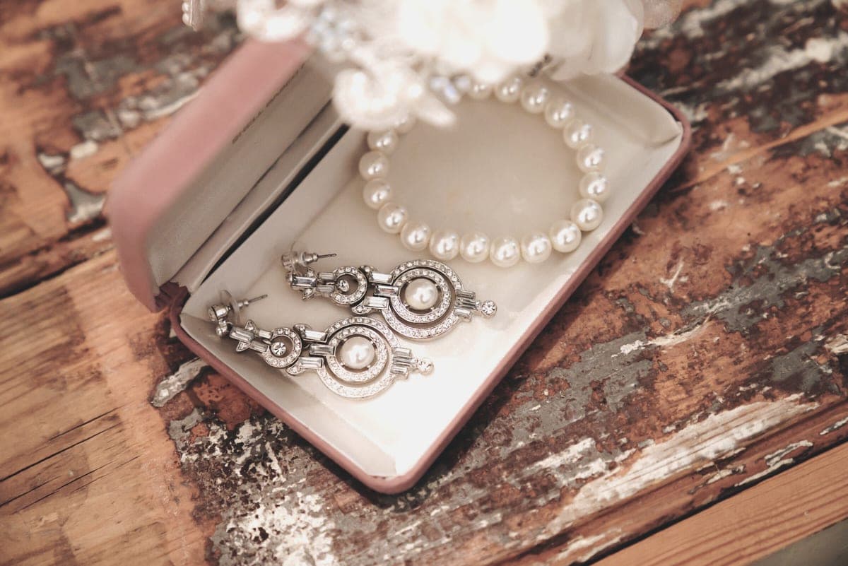 A small open jewelry box holding several pairs of earrings