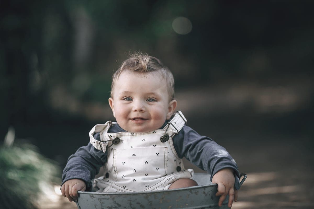 A child smiling outdoors in soft natural light