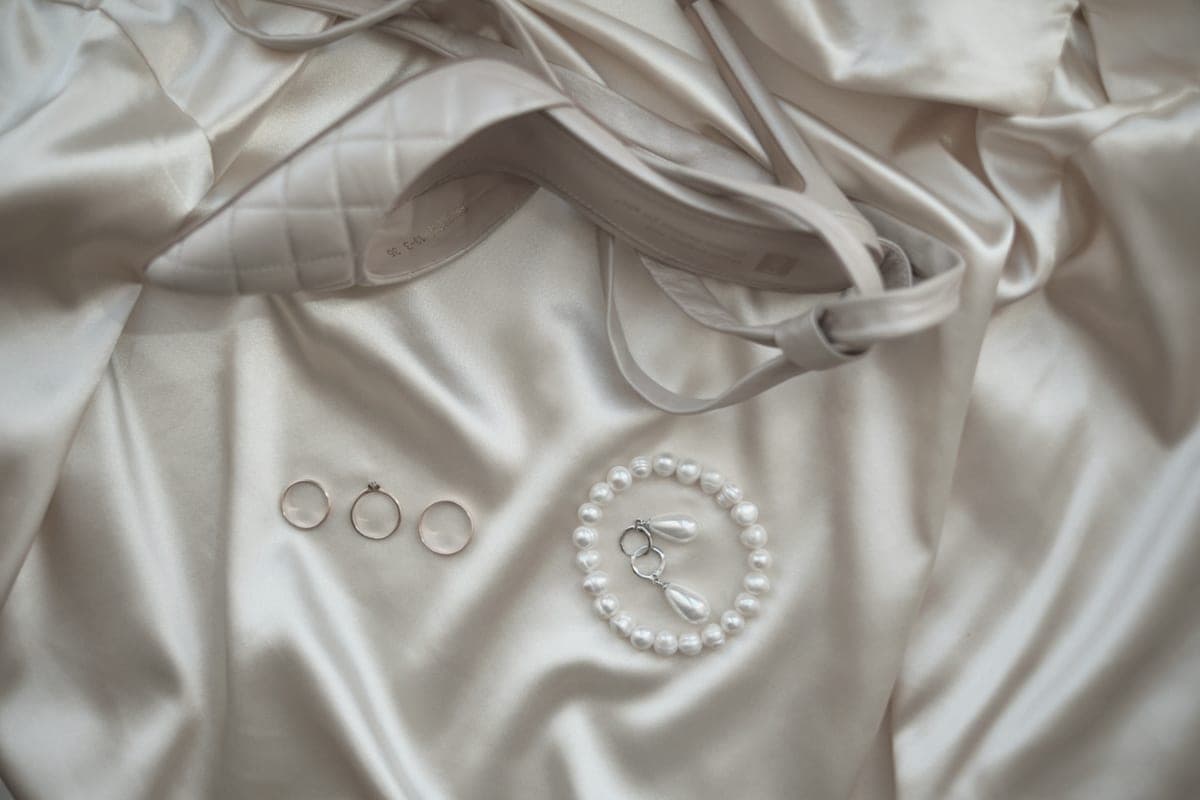 Pearl earrings resting on soft pale fabric