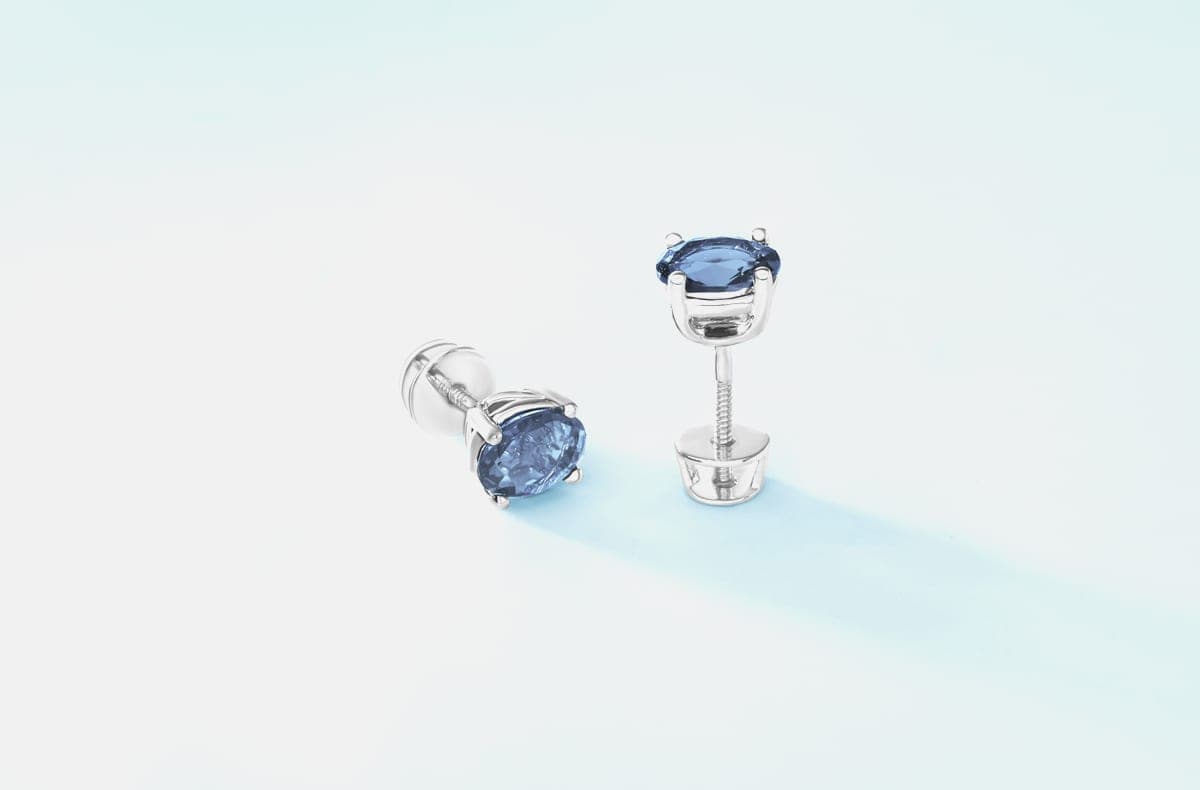 A close-up of an ear wearing two small stud earrings