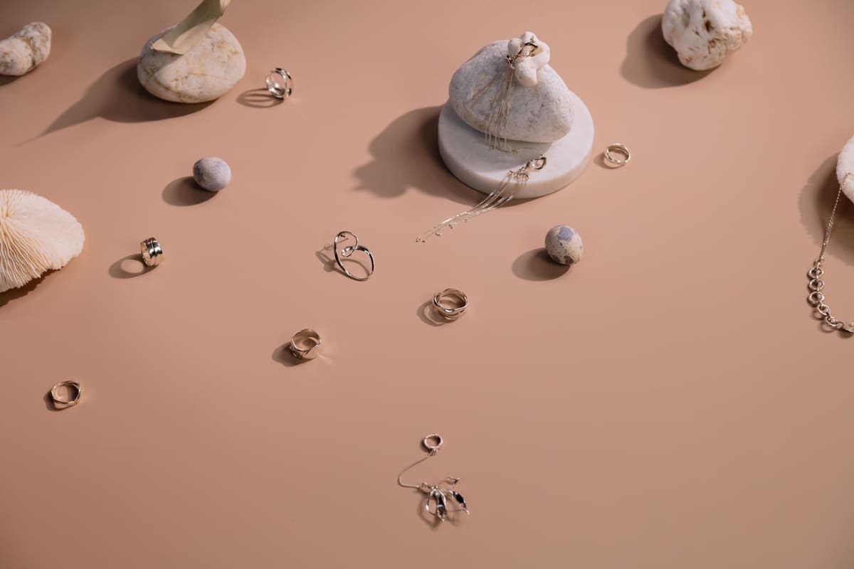 Rings and earrings arranged on a soft terracotta-toned backdrop