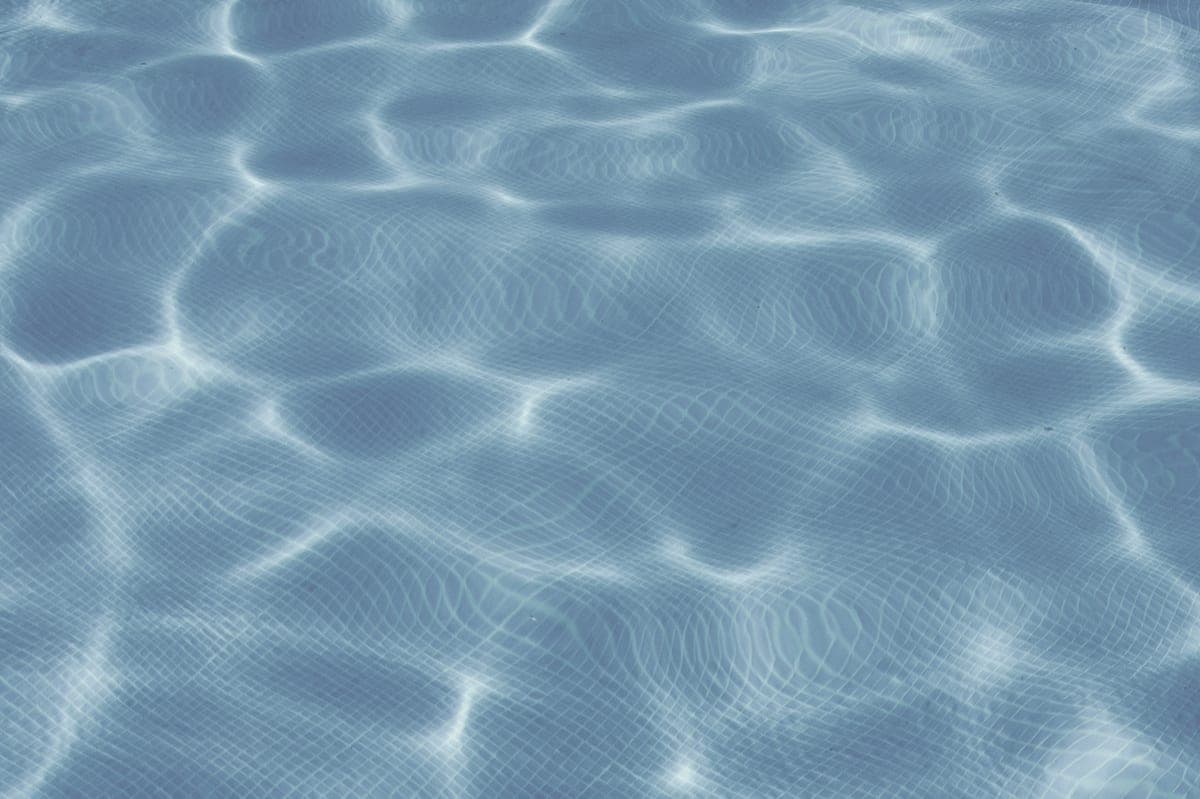 The bright, still surface of a swimming pool in daylight