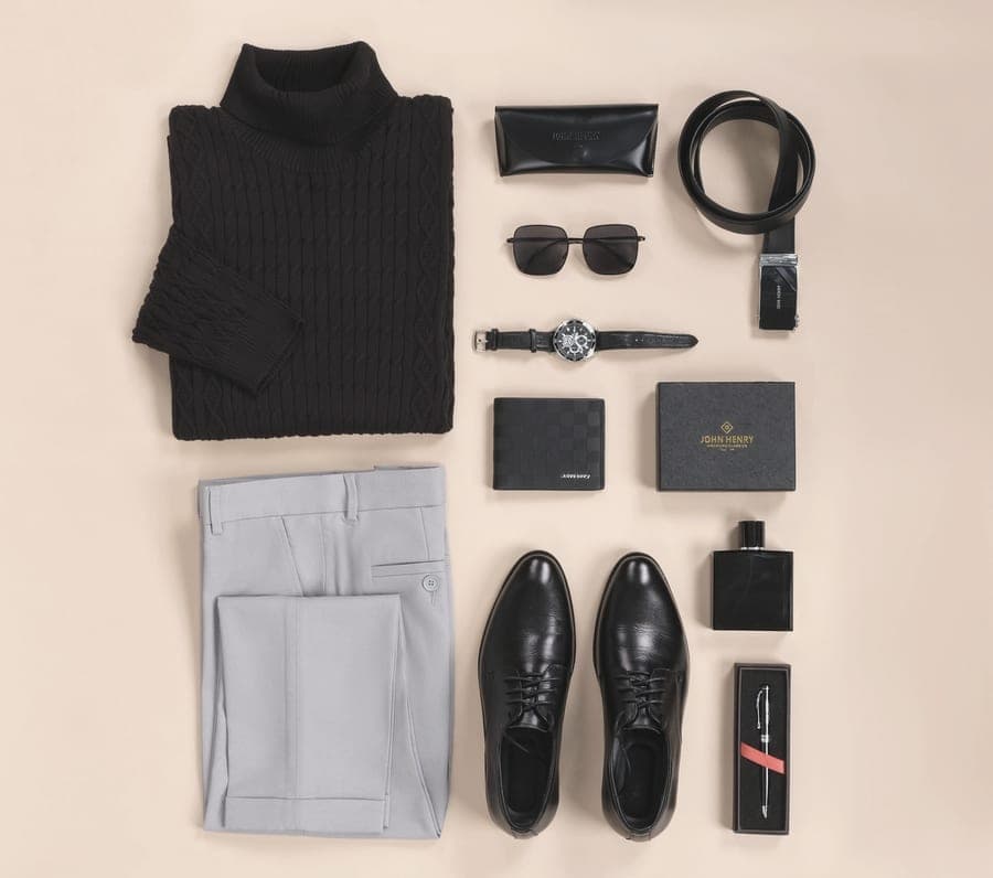 Sunglasses and a wristwatch arranged on a plain, light surface