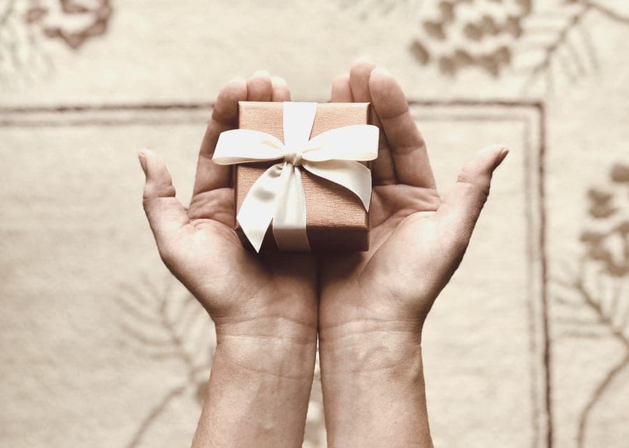 A small jewelry gift box on a neutral, softly lit surface